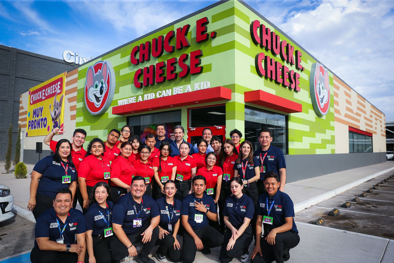 group of chuck e cheese cast members standing outside of a chuck e cheese location